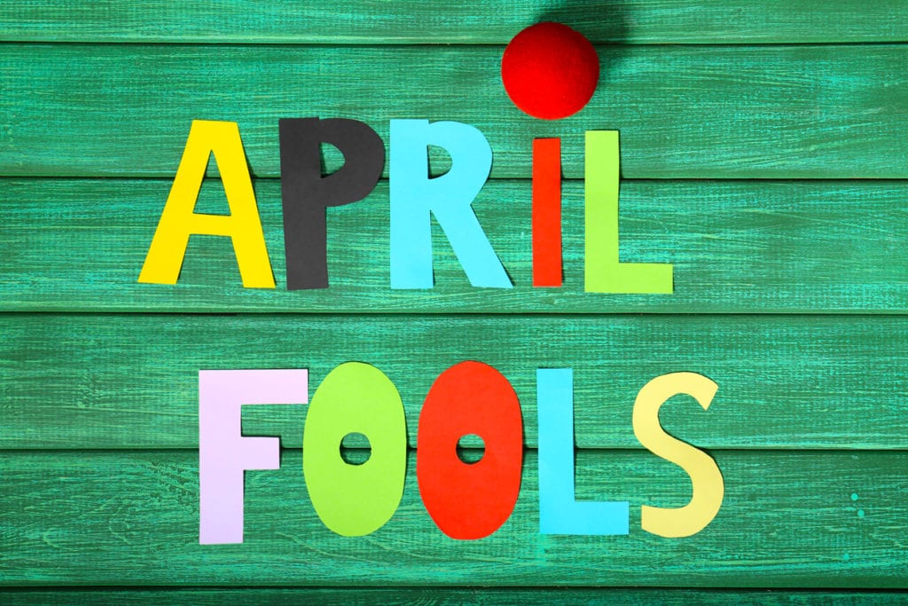 april fools cutout letters on green wooden background