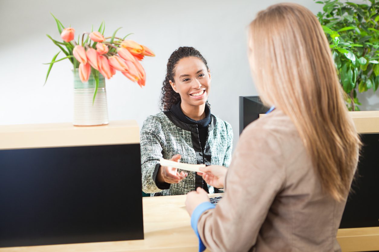 money services business bank teller teller handing receipt to customer