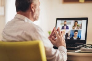 Man working from home having online group videoconference on laptop virtual meeting
